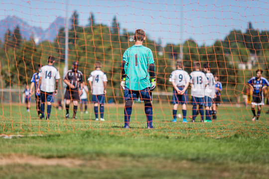 Young soccer goalkeeper and players getting ready for a penalty kick - Powered by Adobe