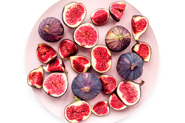 Plate of fresh blue figs on white background top view