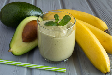 Smoothie with avocado and banana on the grey wooden background