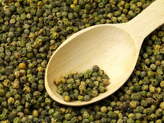 green peppercorn and wooden spoon macro
