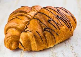 Tasty croissants with spikelets on grey wooden background