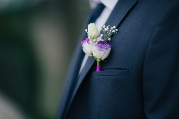 Bright groom boutonniere with baby's breathe and rose