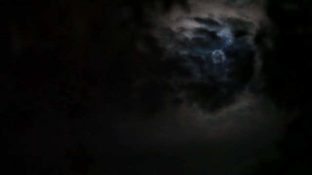 Full Moon in the Night Sky Among the Running Dark Gloomy Clouds