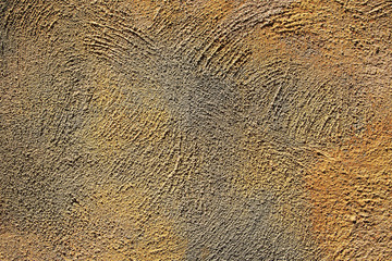 Texture of coarse plaster of yellow and gray colors on the wall