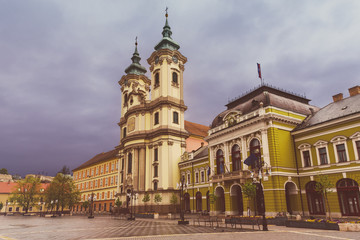 Naklejka na ściany i meble Eger main square in Hungary, Europe with dark moody sky and catholic cathedral. Travel outdoor european background