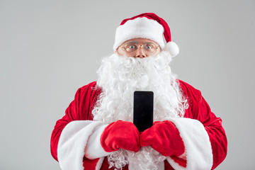 Man in a Santa Claus suit holding a cell phone