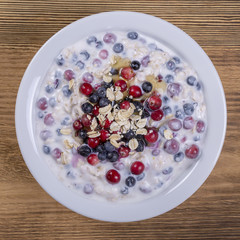 Muesli made from blueberries, cranberry, oat flakes with yogurt and honey, close up