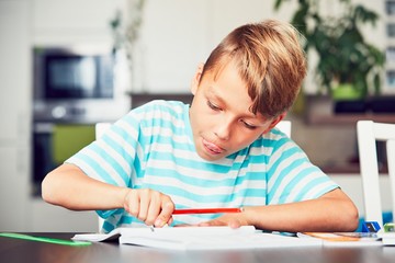 Naklejka na ściany i meble Little boy doing homework