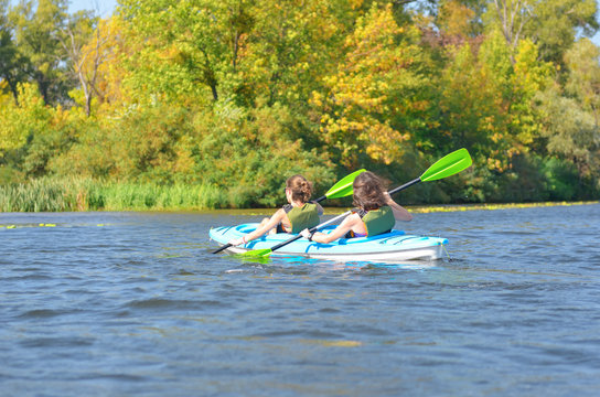 Family kayaking, mother and child paddling in kayak on river canoe tour, active summer weekend and vacation, sport and fitness concept
