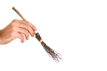 Ancient natural, old wooden broom created from tree branches, which wiped rooms, yards and streets. Autumn leaf sweeping. Janitor's hand holding a small work tool. Isolated on the white background.