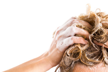 Woman's hand with shampoo washing hair isolated on the white background. Cares about a healthy and clean hair. Beauty salon. Empty place for a text.