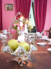 Table served by tea. Traditional tea set with vintage silver  vase with apples.