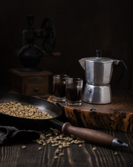 Still life with espresso machine and unroasted coffee beans