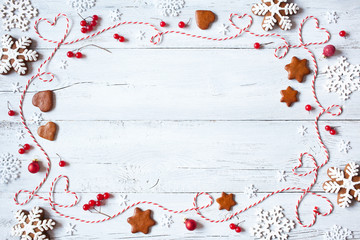 Christmas wooden background with snowflakes, cookies and twine in the form of heart