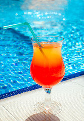 A cocktail on swimming pool background