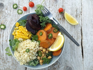 Vegetarian bowl of buddha. The concept of a vegetarian healthy food. Kale cabbage, bulgur, chickpeas, corn, baked sweet potato and beetroot.