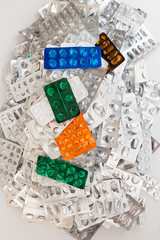 Heap of empty assorted various medicine tablets pills blisters different colors on white background. Healthcare or medicament addiction concept.