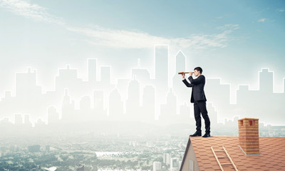 Engineer man standing on roof and looking in spyglass. Mixed med