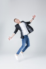  handsome man in jeans and jacket jumping