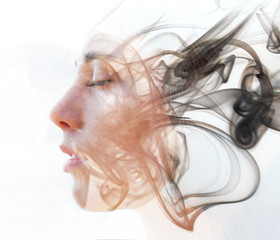 Double exposure portrait of a young fair-skinned woman and a smoky texture dissolving into her...