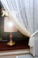 Fototapeta Złota lampka nocna na parapecie okna. obraz