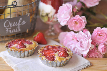 classic cheesecake with strawberries. on a light background with a bouquet of wildflowers in a jar. Chamomile. Decor of vintage textiles