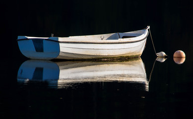 White small boat on dark still water