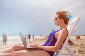 Woman with laptop on the beach