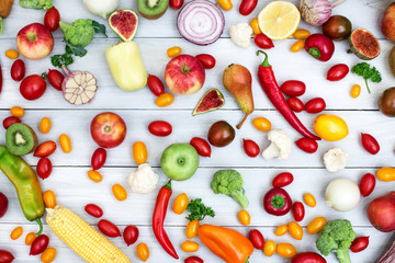 Different vegetables and fruits on a wooden background top view.