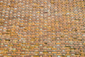 Background wall is red ancient bricks. The structure of brick. Orange textured fence. Architectural...