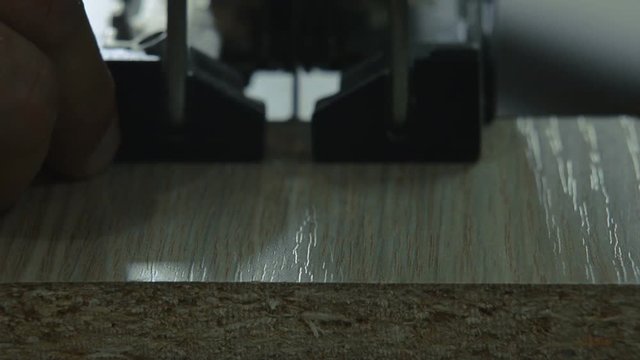 electric jigsaw cuts laminated board
