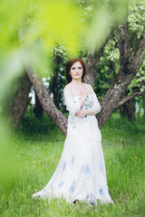 Obraz na płótnie Canvas Woman in long white dress in summer garden