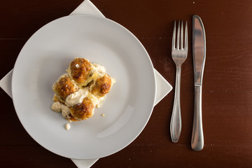 Flat lay above minced meat meatballs with cheese and fork and knife