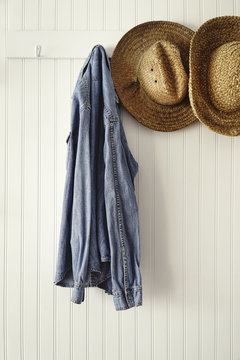 Shirt and straw hats hanging on hooks