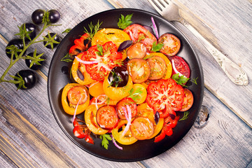 Tomato, basil, parsley, dill and onion salad. View from above, top studio shot, vertical