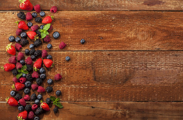 Ripe and sweet berries on wooden background