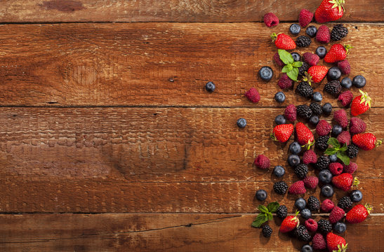 Ripe and sweet berries on wooden background