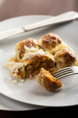 Closeup macro of sliced meatballs with cheese served on the plate