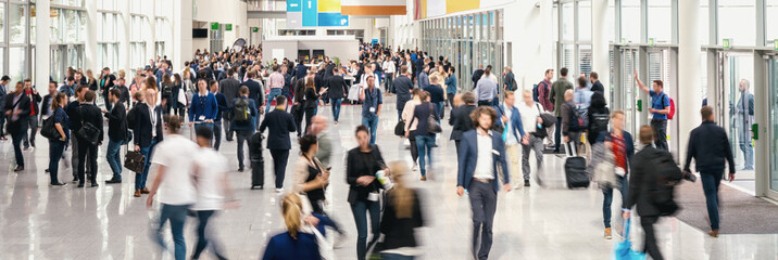 large crowd of anonymous blurred people at a trade fair