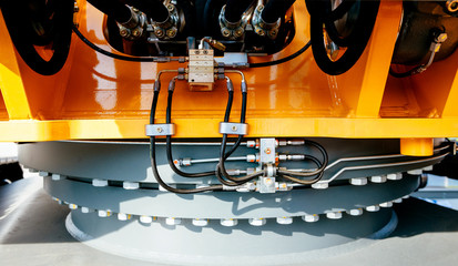 Under the excavator - detail of the swing drive and slewing ring of modern powerful excavator on a construction site © ifeelstock