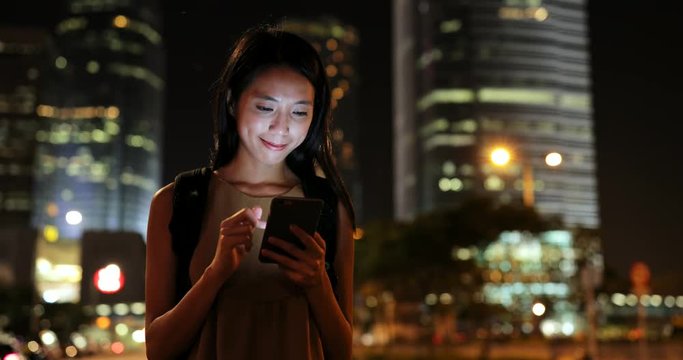 Woman using mobile phone at night