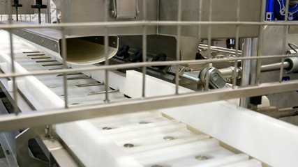 Food factory automated robotic machine. Conveyor product line for cooking and packing rations and food packs. Robotics and automatic lines used instead of human labor on factories and plants.