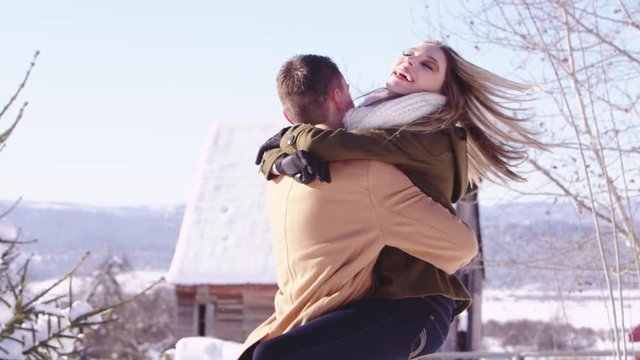 Young woman jumping into her boyfriend's arms in the winter