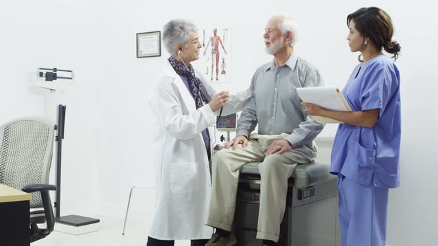 Doctor and nurse checking elderly patients heart beat
