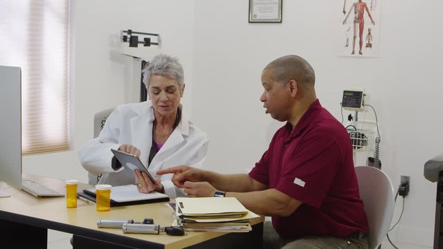 Doctor using tablet to speak with patient