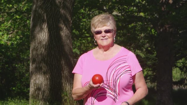 Elderly woman holding bocce ball