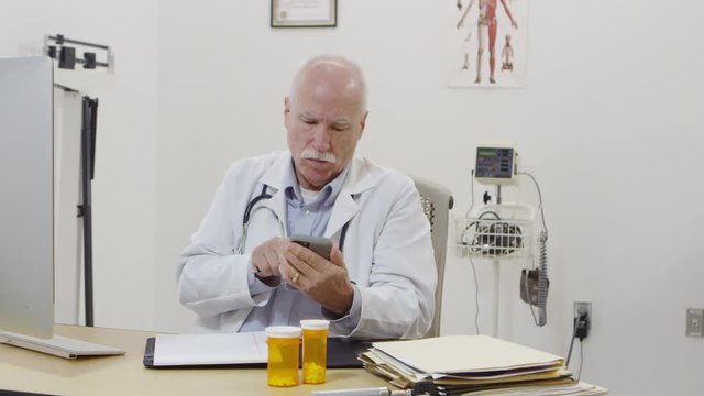 Elderly doctor calling and using cellphone