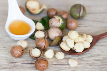Closeup view of natural macadamia oil and Macadamia nuts on wooden board. Healthy food