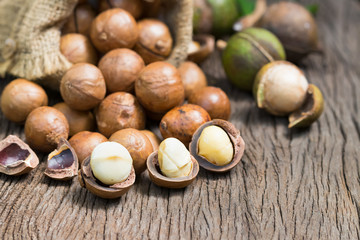 Closeup view of natural macadamia oil and Macadamia nuts on wooden board. Healthy food