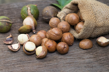 Closeup view of natural macadamia oil and Macadamia nuts on wooden board. Healthy food